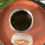 exture du gommage au café naturel – grains exfoliants riches en café et karité pour une peau lisse et revitalisée.